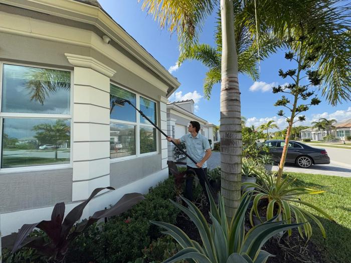 Crystal Bear technician cleaning exterior windows on a residential home